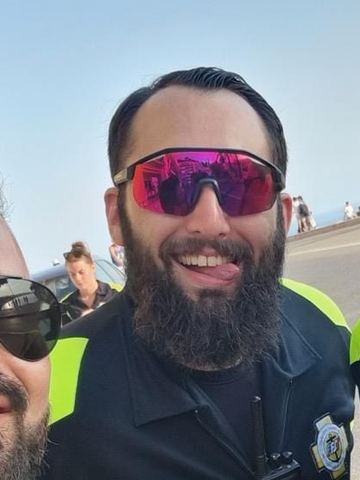 Guillaume en polo d’équipier, lunettes de soleil, sur le front de mer.